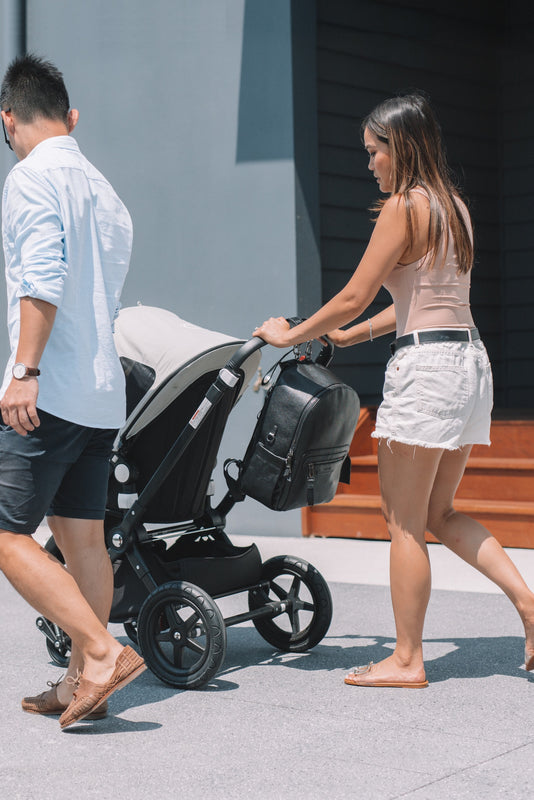 Parents walking with Pram with ONE NINE Pram Clips